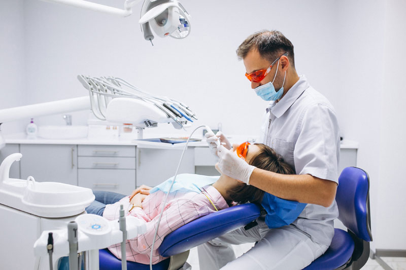 A dentist examining a patient's mouth.