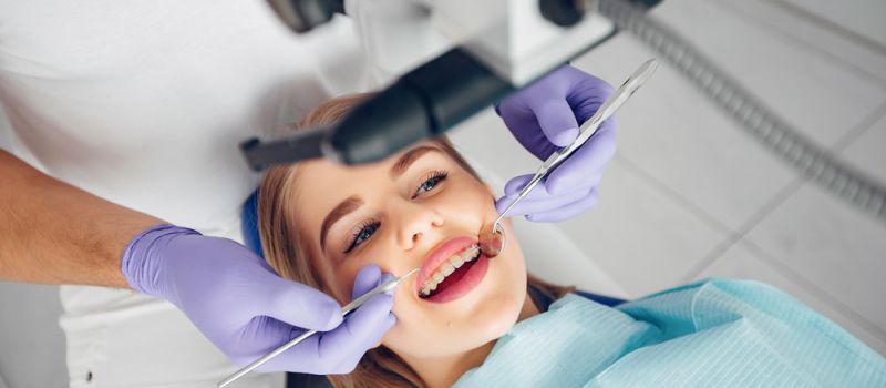 A dentist examining a patient's mouth.