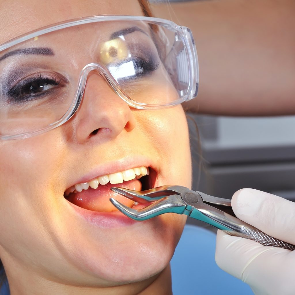 Patient in protective glasses during a tooth extraction