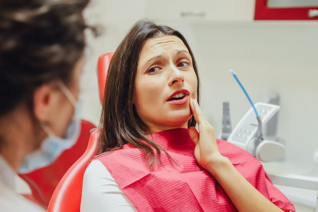 Patient holding her jaw because of tooth pain