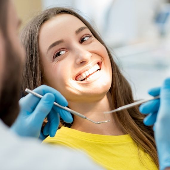 A woman sitting in a dentist's chair.
