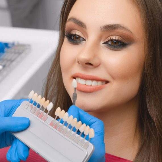 Dentist matching veneer shades to a patient's smile